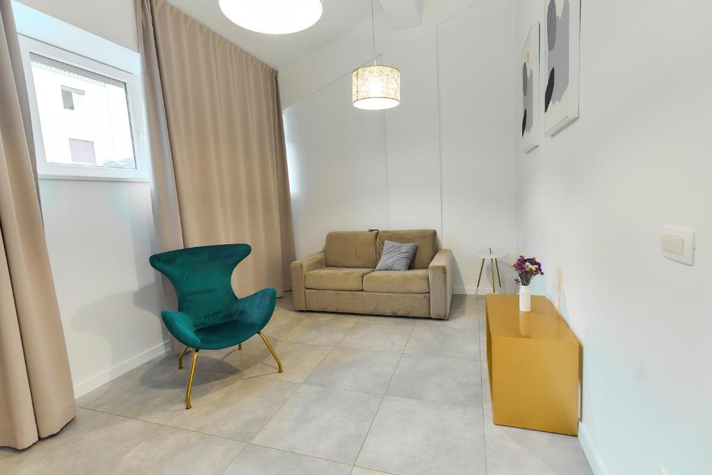 een woonkamer met een groene stoel en een bank bij Apartments Lukas 5 in Zadar