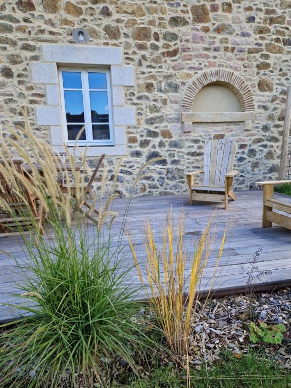 a chair sitting on a deck next to a building at Magnifique maison de vacances - Wunderschönes Ferienhaus in Pléneuf-Val-André