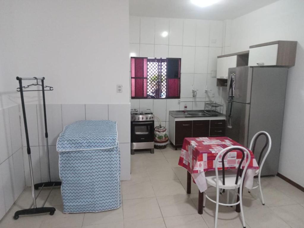 a small kitchen with a table and a refrigerator at JK térreo Zona Norte in Porto Alegre