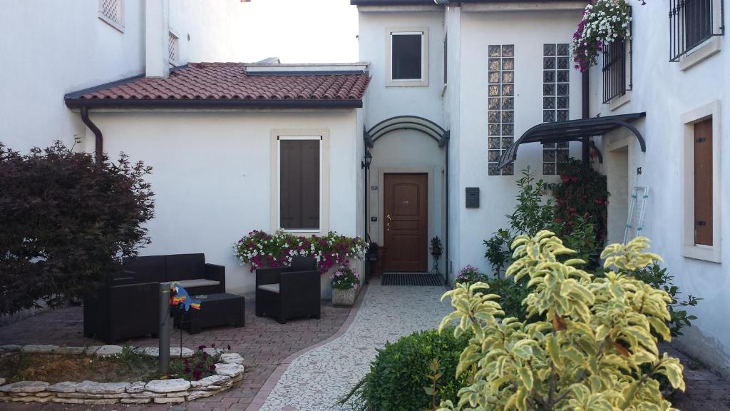 a courtyard of a white house with a door at Appartamento Acero Rosso in Vicenza