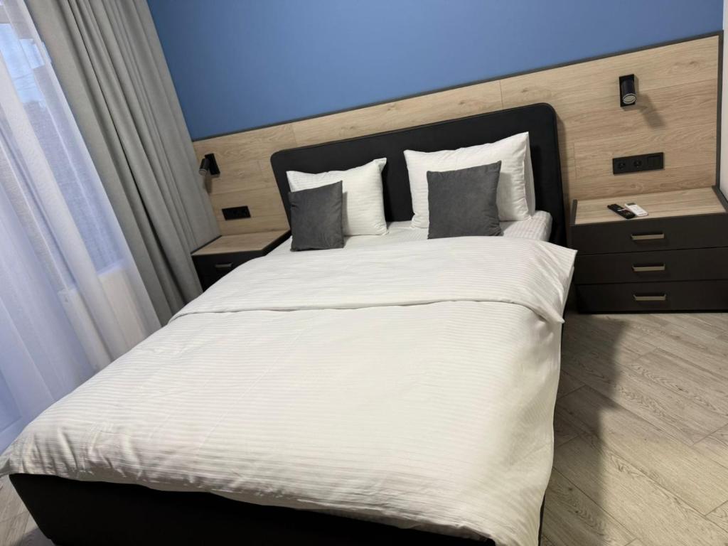 ein Schlafzimmer mit einem großen Bett mit weißen Laken und Kissen in der Unterkunft Apartments on Sennaya Street in Mykolajiw