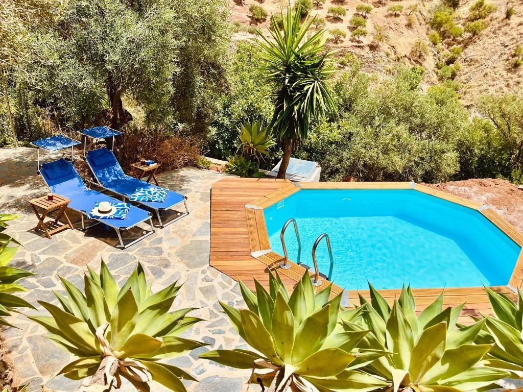 una piscina con terraza y sillas y una piscina en Casa Blanca y Azul, en Almogía