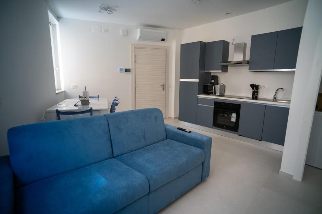 a blue couch in a living room with a kitchen at 14 Nevoso Palace in Milan