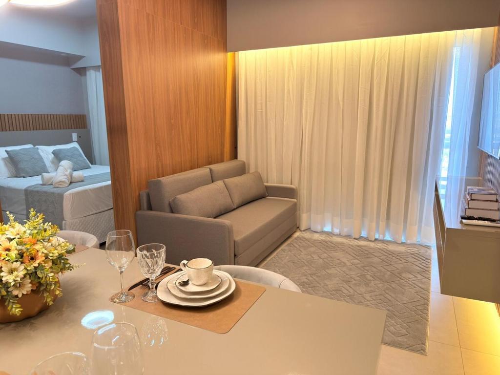 a room with a dining table and a living room at Apartamento com aconchego e modernidade in Ribeirão Preto