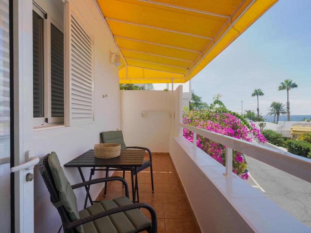 een balkon met een tafel en stoelen en uitzicht op de oceaan bij Nueva Suecia By CanariasGetaway in San Agustin