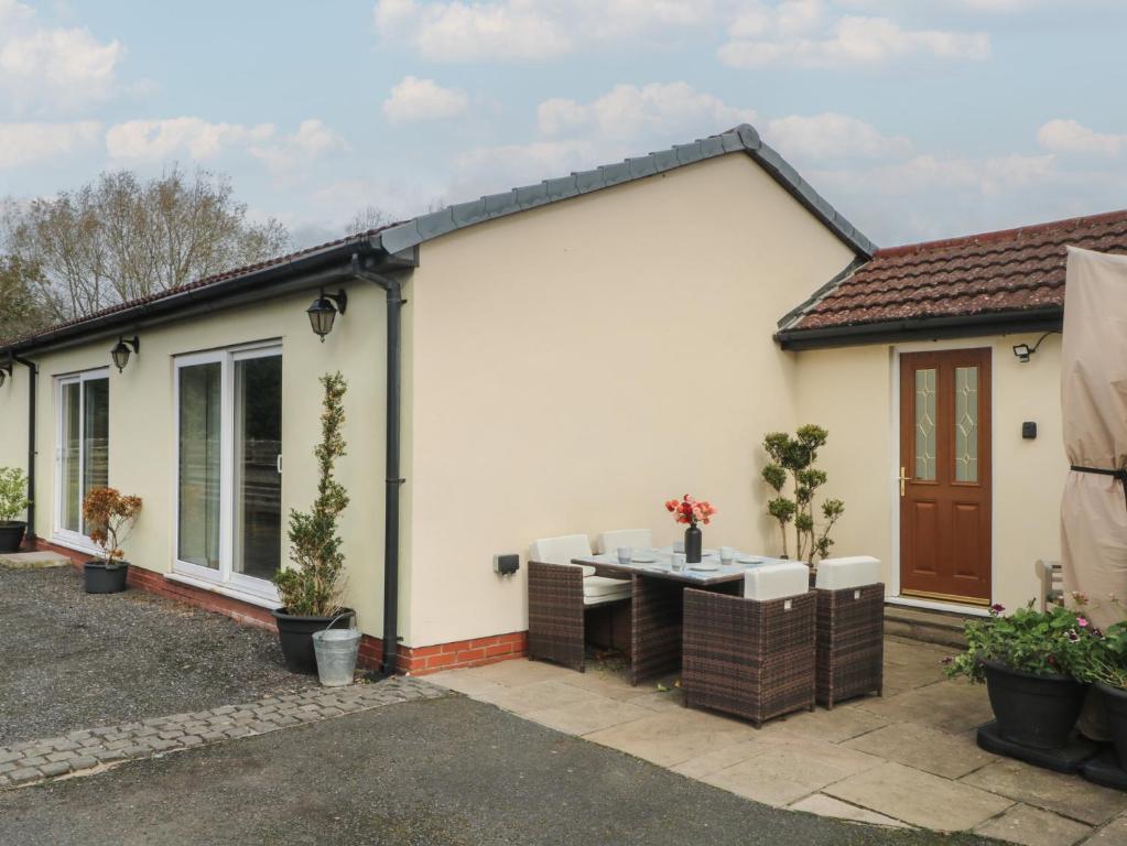 Una casa unifamiliar con mesa y sillas en el exterior. en Pompian Lodge, en Bretherton