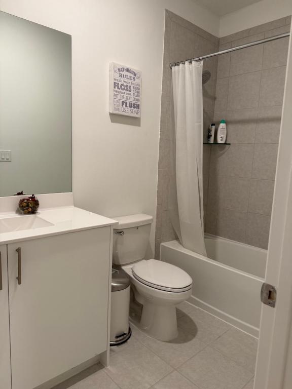 a white bathroom with a toilet and a shower at Villa BRIGORO in Homestead