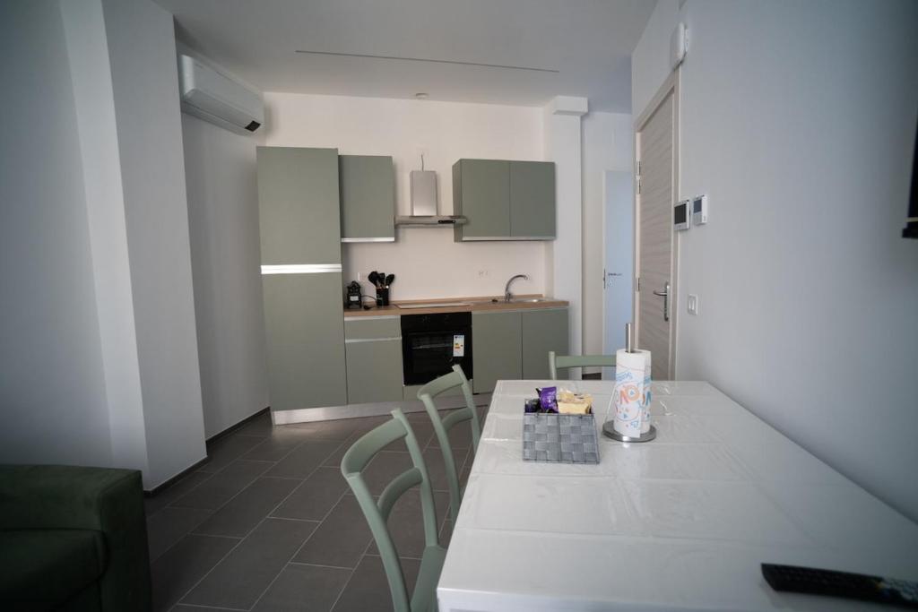 una cucina con un tavolo bianco e sedie in una stanza di 15 Nevoso Palace a Milano