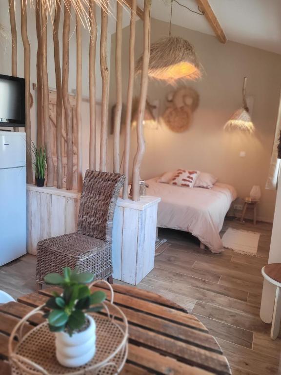 a bedroom with a bed and a chair and a table at Bel des Prés - Cocùn - Piscine partagée in Carquefou
