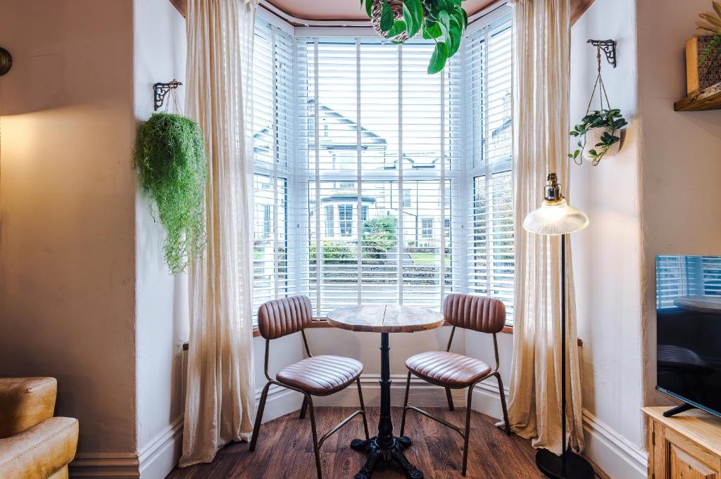 Rufloreo Flats 1 - central gem في بكستون: طاولة وكراسي في غرفة بها نافذة