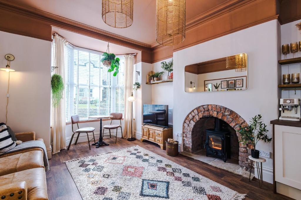 a living room with a fireplace and a table at Rufloreo Flats 1 - central gem in Buxton