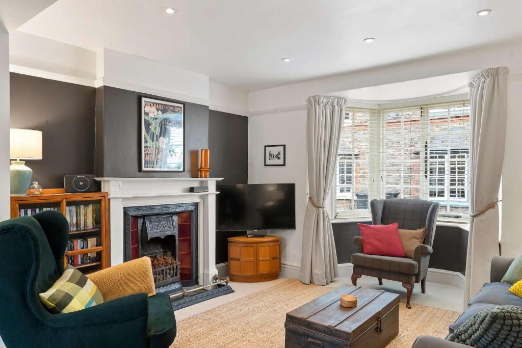 a living room with a fireplace and a tv at Cottage in central Porlock with garden & parking in Porlock