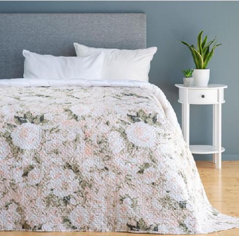 a bed with a floral bedspread and a white night stand at Svečių namai pas Jud ir Ram in Šiauliai