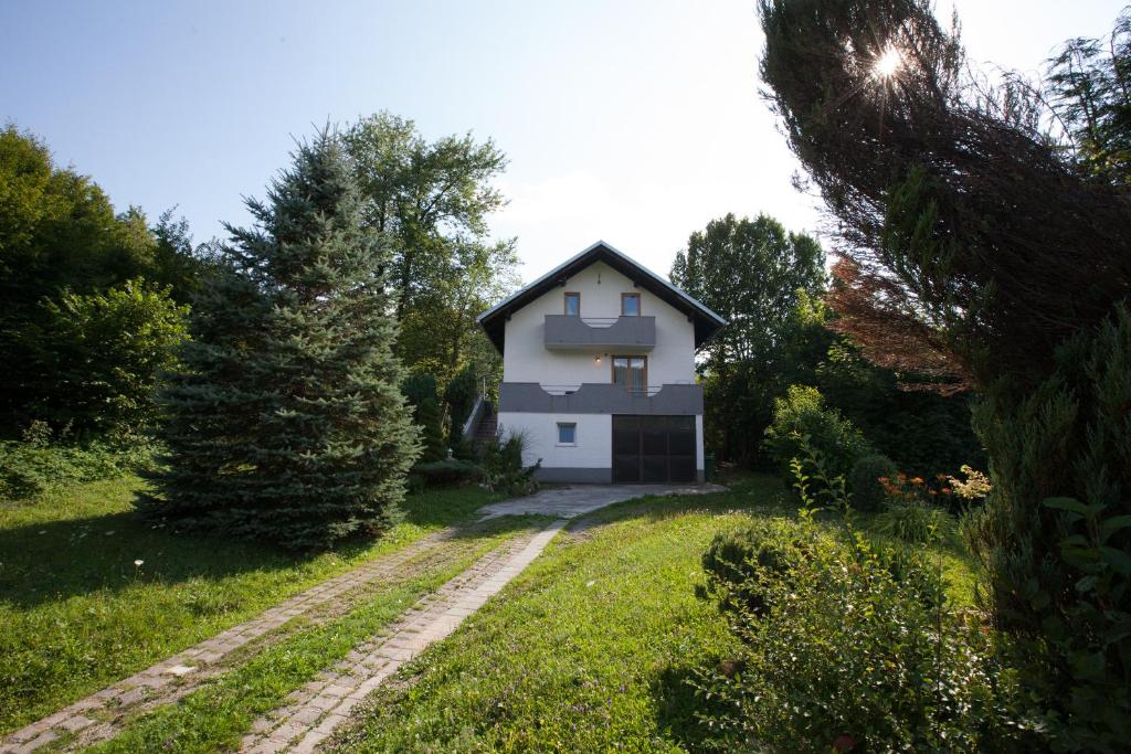 a white house in the middle of a yard at Holiday Home Tin in Ogulin