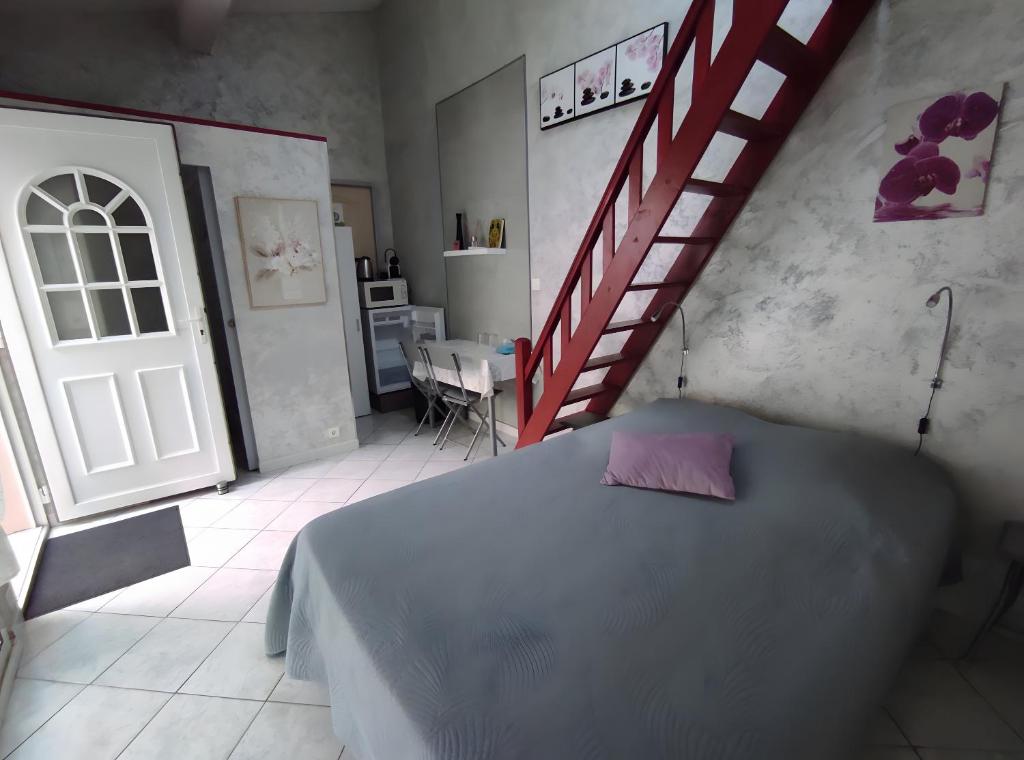 a bedroom with a bed and a staircase in it at Chambres d'hôtes - Les Orchidées in Perpignan