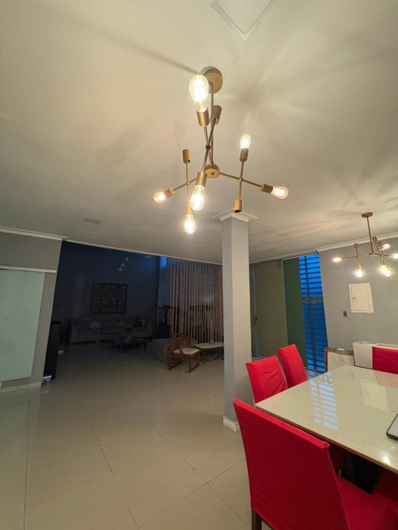 a living room with a table and red chairs at Casa completa para cop 30 in Belém
