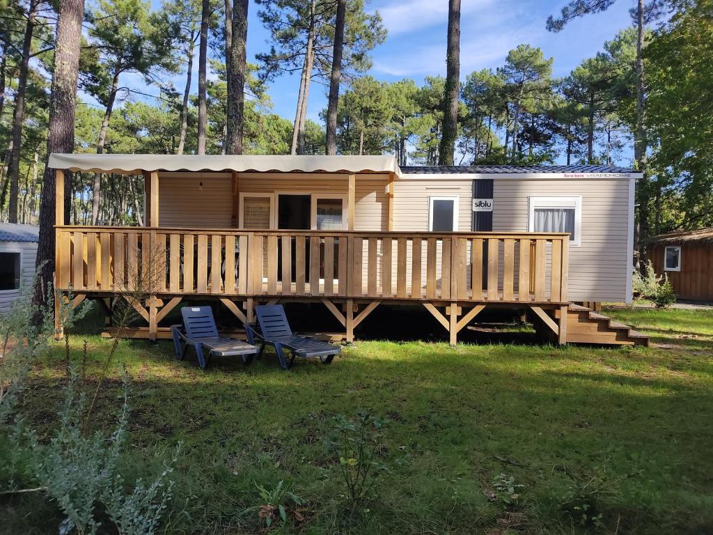 a tiny house on a deck with two chairs at Superbe mobil-home à Seignosse plage in Seignosse