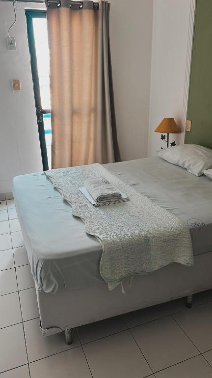 a bedroom with a bed and a window with a curtain at Hotel Serra Sol in Serrinha