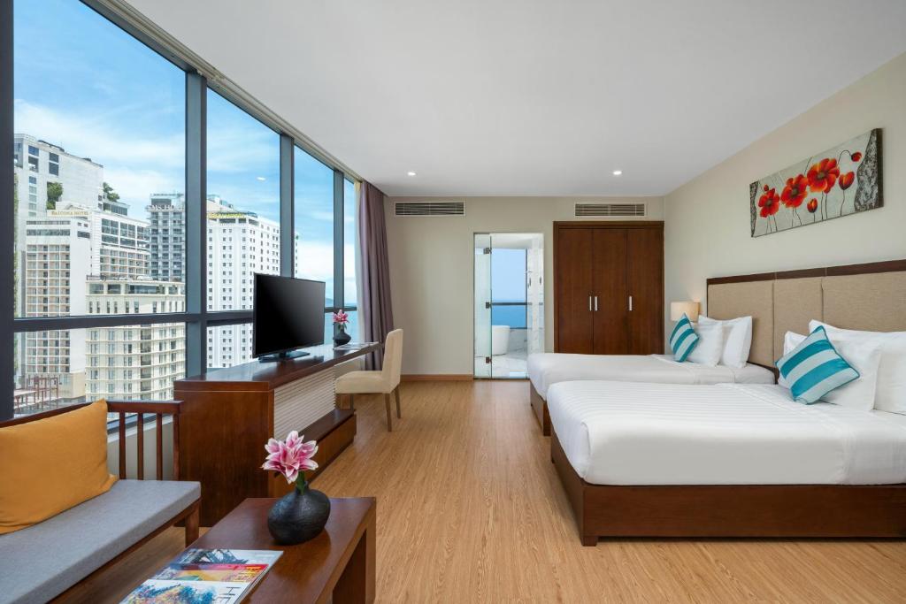 a hotel room with two beds and a television at Avatar Danang Hotel in Danang