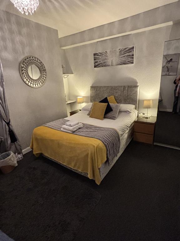 a bedroom with a bed and a mirror on the wall at The Georgian Guesthouse in Alnwick