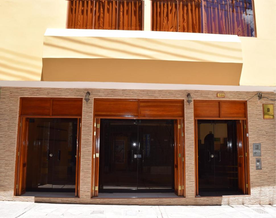 zwei Eingänge zu einem Gebäude mit Holztüren in der Unterkunft Illariy Hotel in Huancavelica