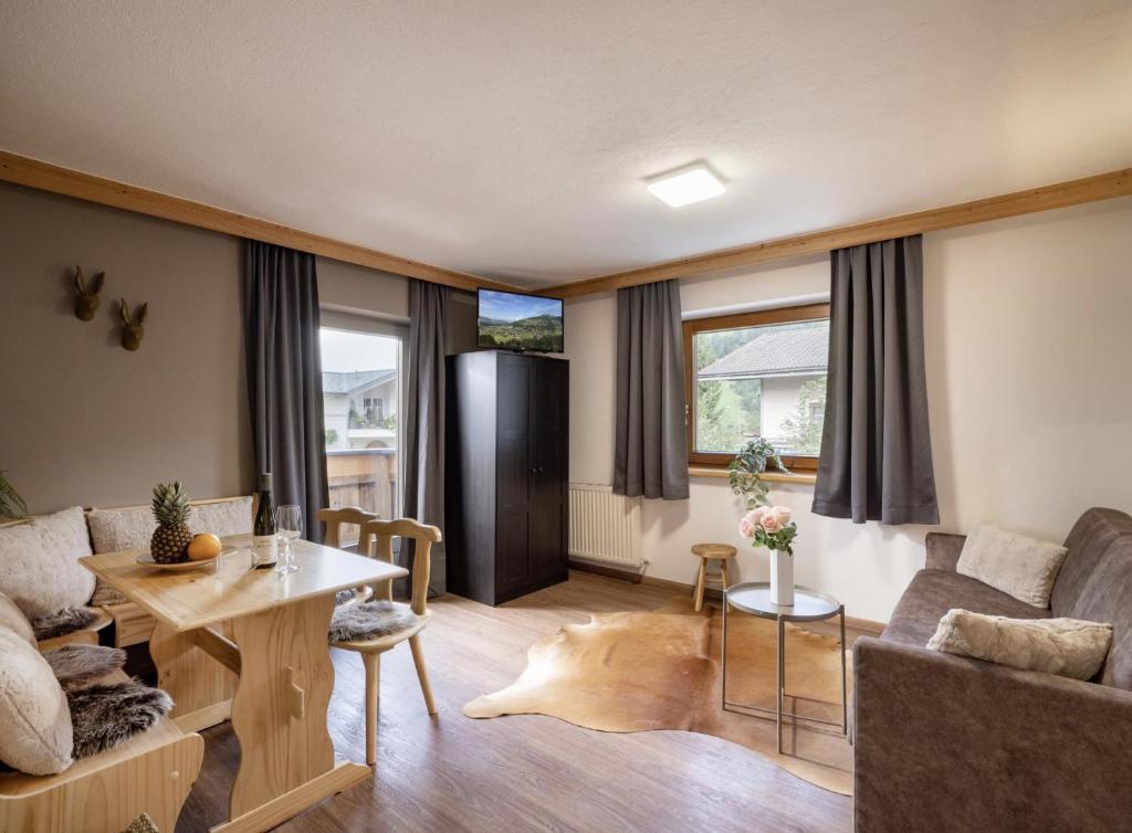 un salon avec un canapé et une table dans l'établissement Haus Adler by Alpine Host Helpers, à Westendorf