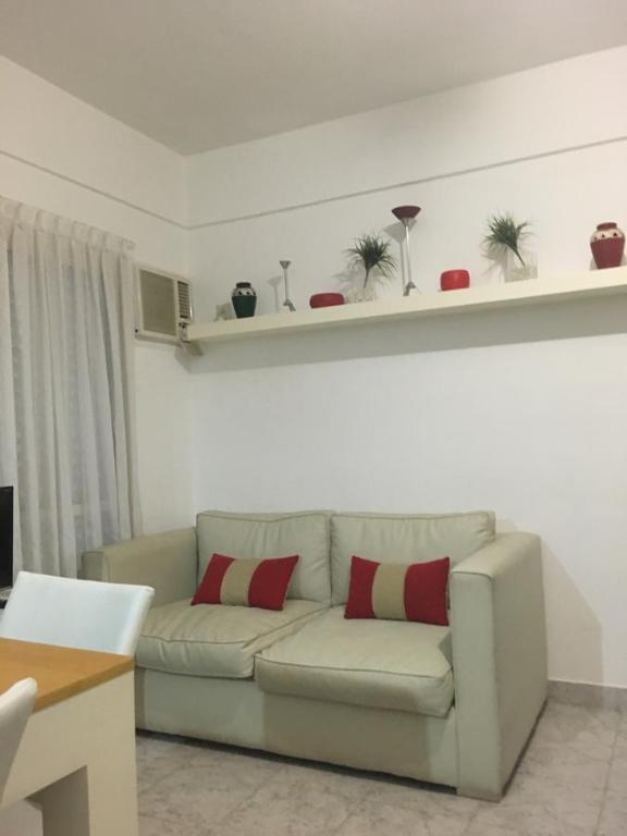 uma sala de estar com um sofá com duas almofadas vermelhas em Apartamento Los Abuelos em Colón