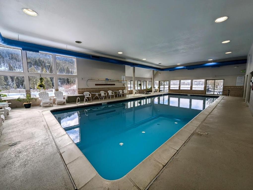 a large swimming pool with blue water in a house at Clearwater Lofts Bldg 3 103 by SummitCove Lodging in Keystone