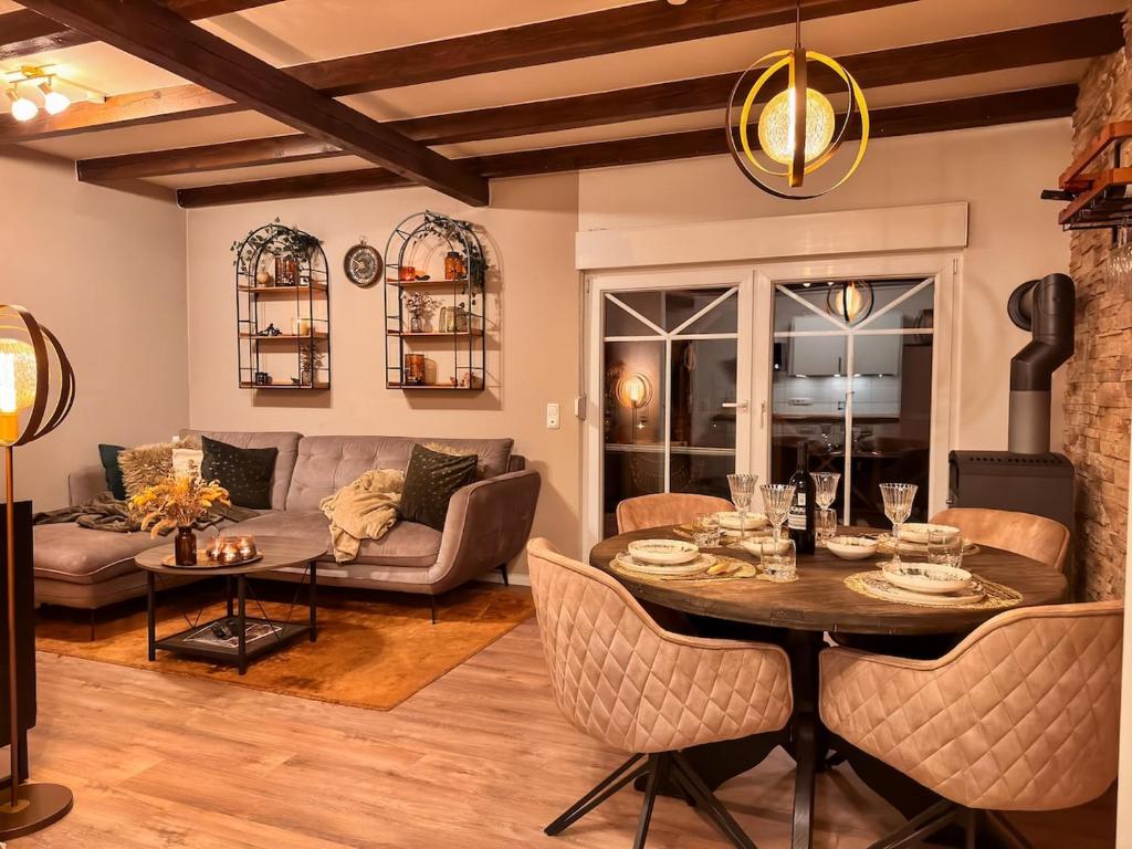 a living room with a table and a couch at Stall & Glut - Landhaus mit Sauna & Kaminofen in Bad Zwischenahn