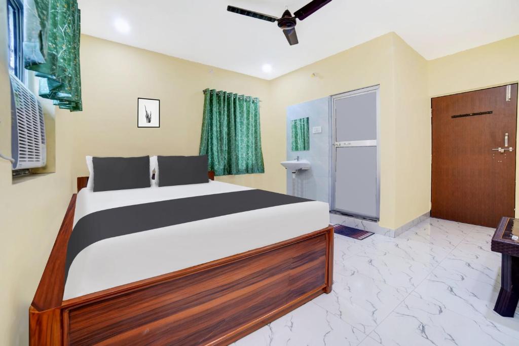 a bedroom with a large bed and a door at Hotel O MAREENA INN in Jamshedpur