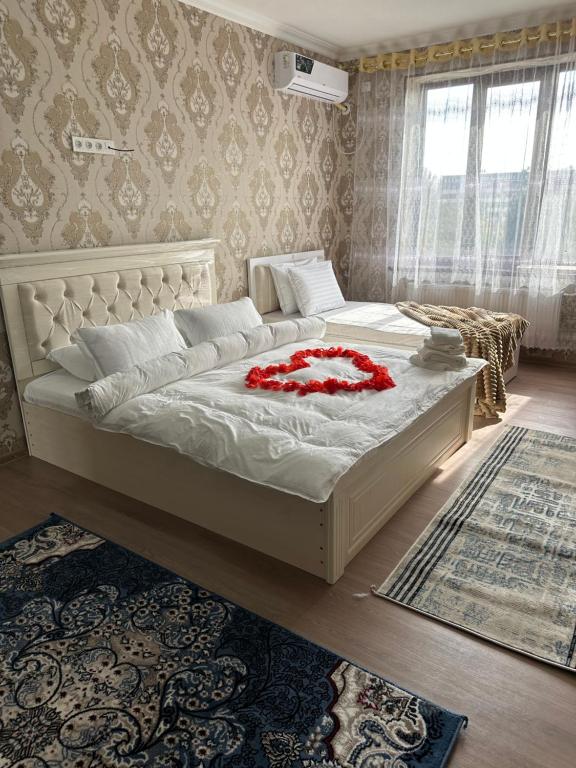 a bedroom with a large bed with red flowers on it at Welcome home apartments in Samarkand