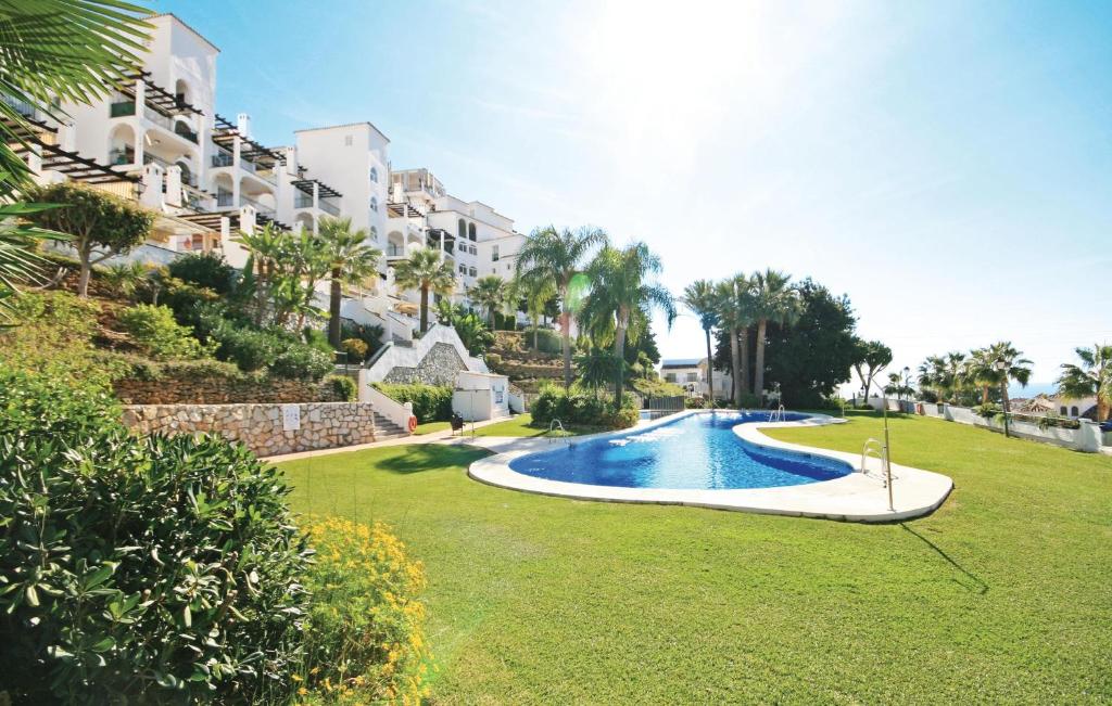 a swimming pool in the middle of a lawn with a building at El Mirador De Calahonda in La Cala de Mijas