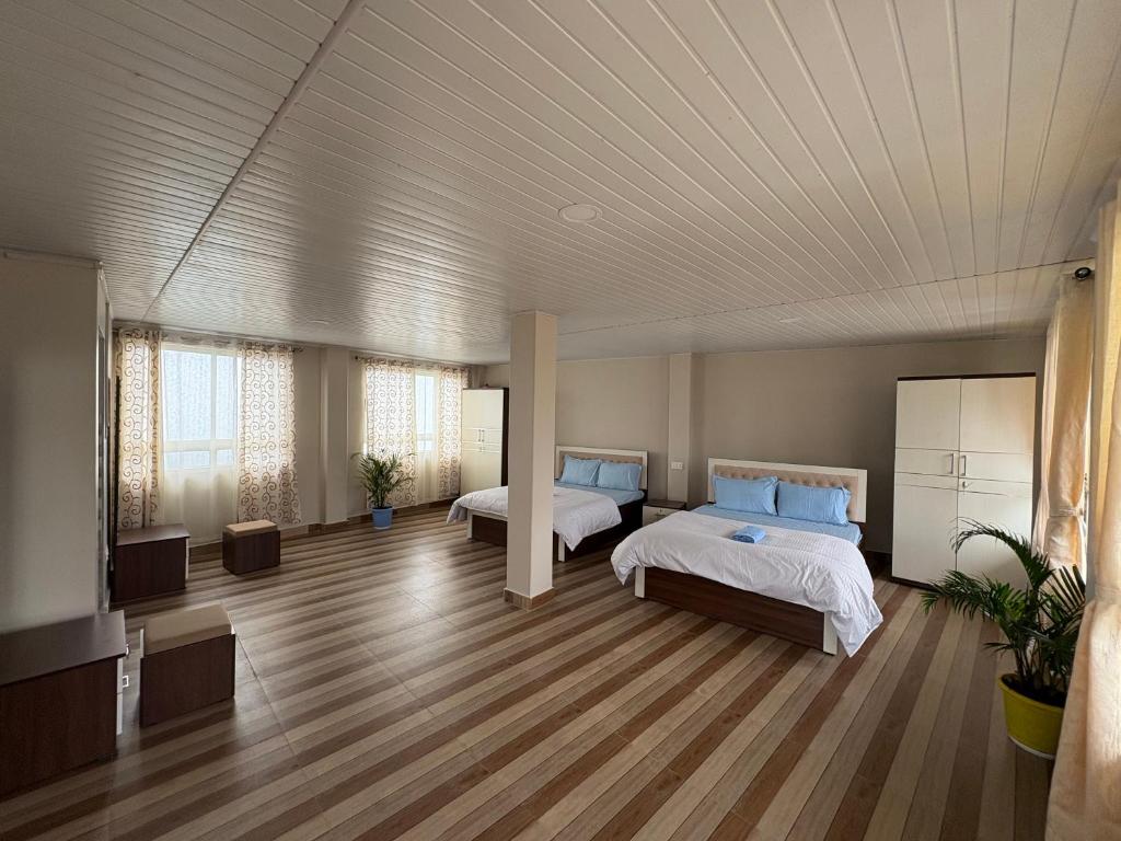 a large room with two beds and a television at Samendu bhawan in Mirik