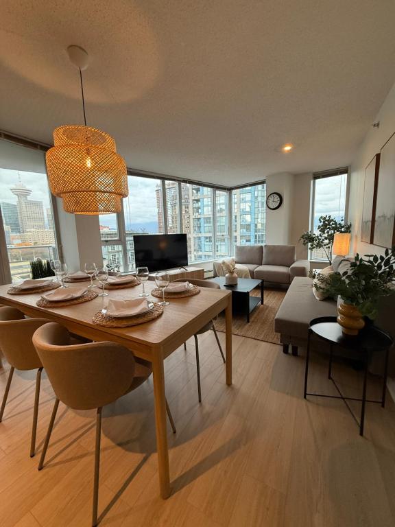 een woonkamer met een tafel met stoelen en een bank bij The Altitude with Mountain & City Views, Pool & Hot Tub in Vancouver