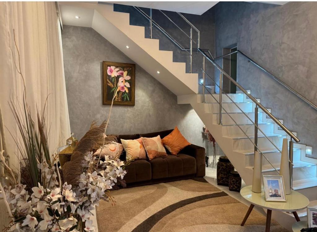 a living room with a couch and a staircase at Lar dos Fernandes in Belém