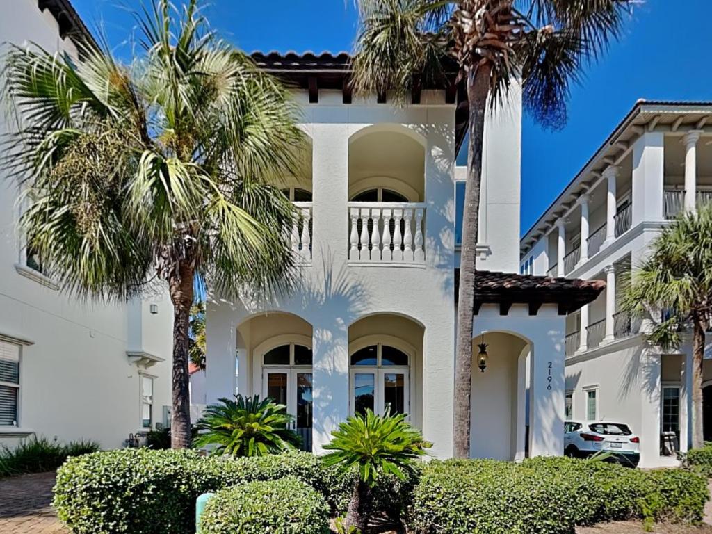 a white house with palm trees in front of it at Blue Mountain Bella in Blue Mountain Beach