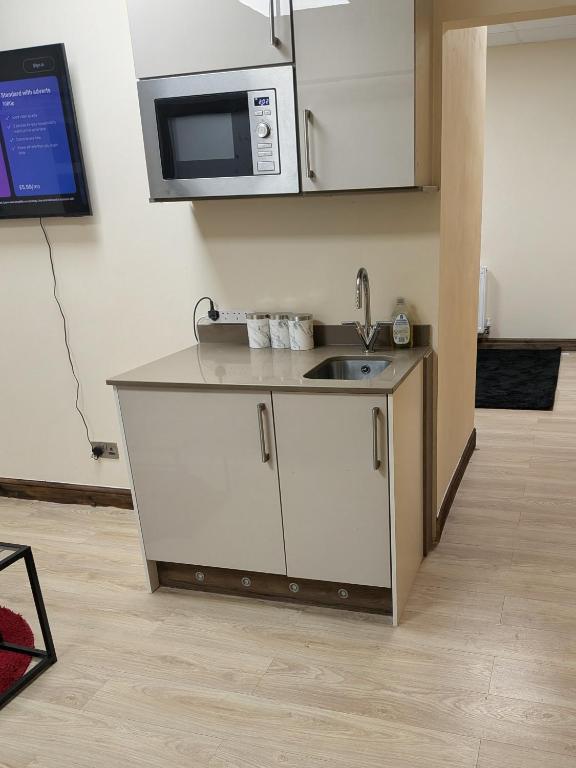 a kitchen with a sink and a microwave at Allen's property with Air conditioner in Birmingham