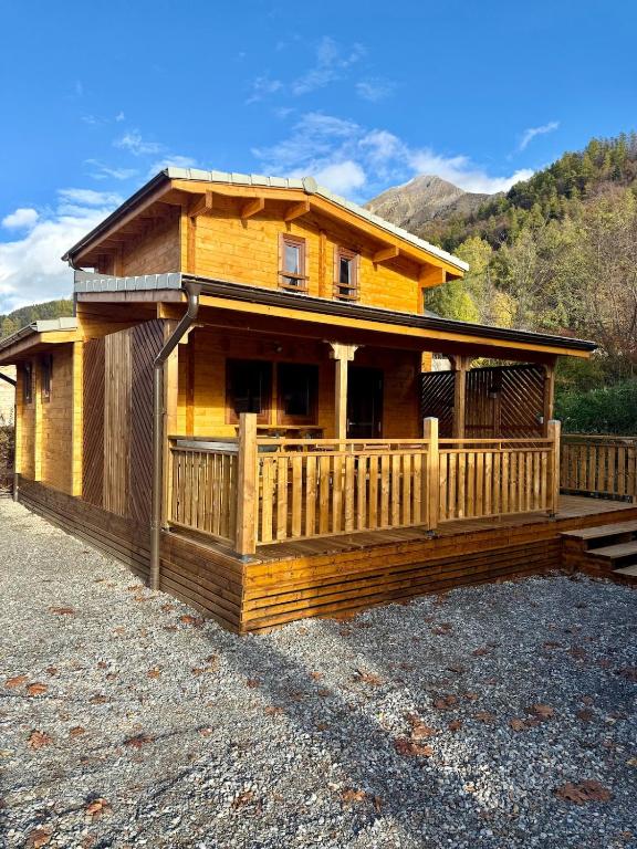 a wooden cabin with a fence in front of it at Le Chalet de la Vernie in Saint-Léger-les-Mélèzes
