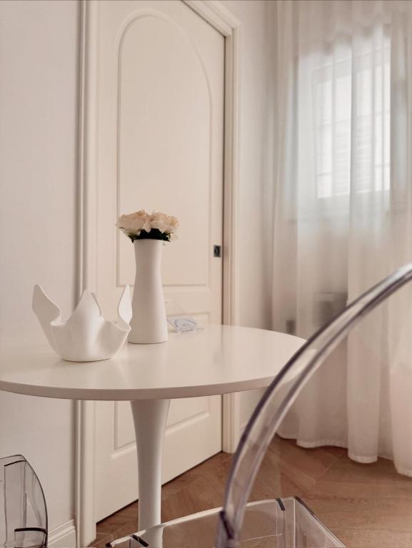 a white table with a vase with flowers on it at DIMORA CARDUCCI in Bari