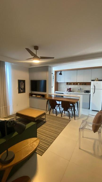 ein Wohnzimmer mit Tisch und Küche in der Unterkunft Ap Conforto 1002 - On São Mateus ar cond in Juiz de Fora