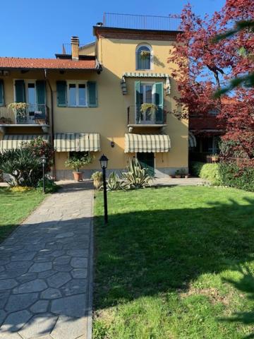 a large house with a grass yard in front of it at La casa di nonna Rosmi in Saluzzo