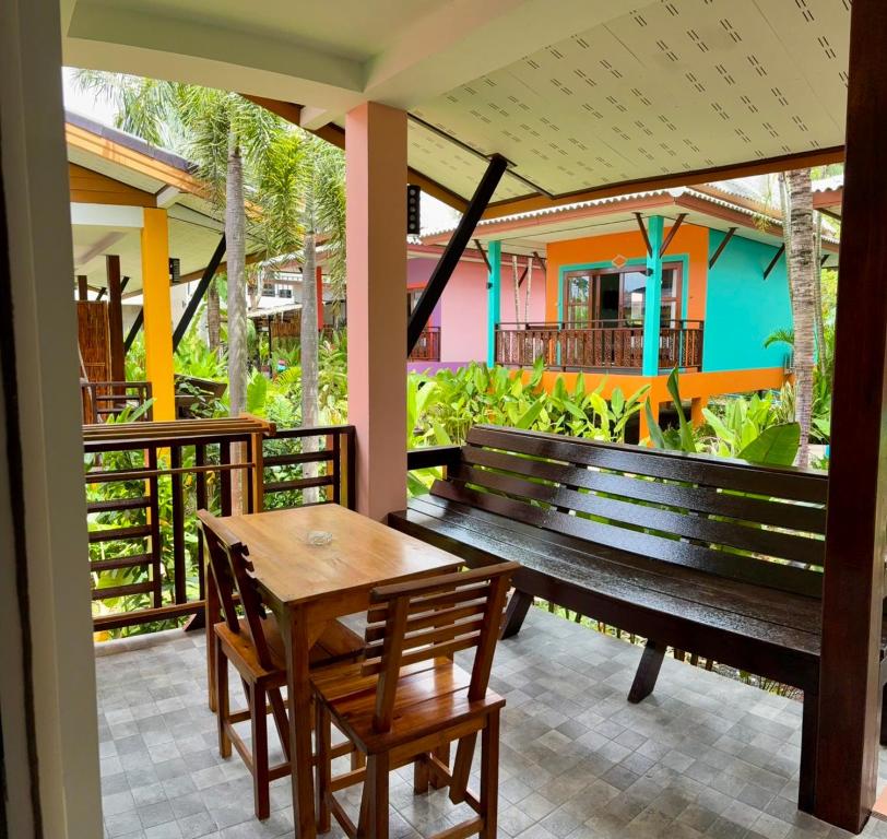 a wooden bench and table on a patio at Lanta Just Come Resort in Ko Lanta Yai