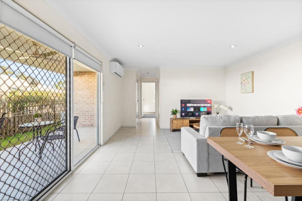 a living room with a couch and a table at Cozy 2BR Home Quiet Bellbird Park Stay in Bellbird Park