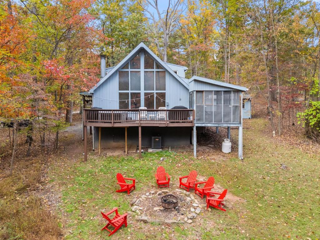 a house with red chairs in front of it at Wooded Chalet w Hot Tub & Indoor Pool, Gym Access in Hedgesville