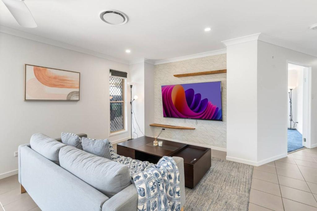 un salon avec un canapé et une table dans l'établissement Cozy Family Home near Shops and Transport with Pool, à Marsden