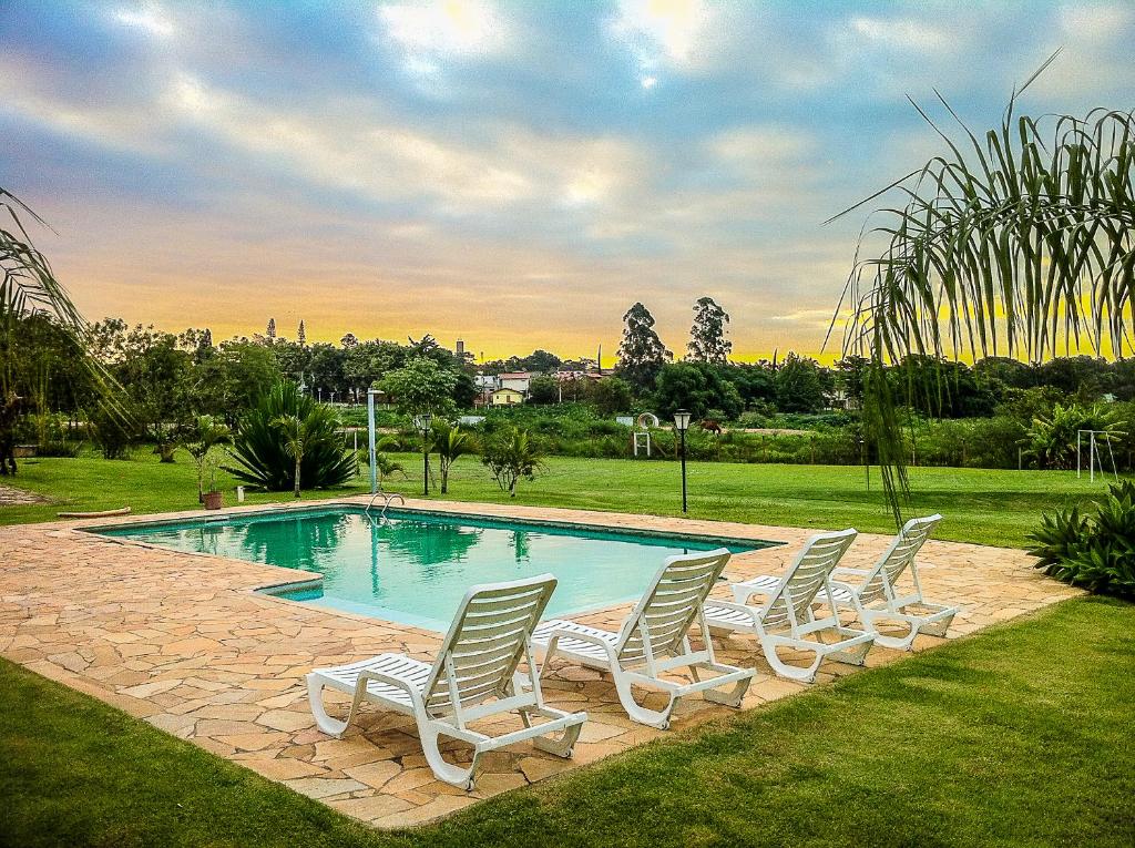 a group of chairs sitting around a swimming pool at Parque Hotel Holambra in Holambra