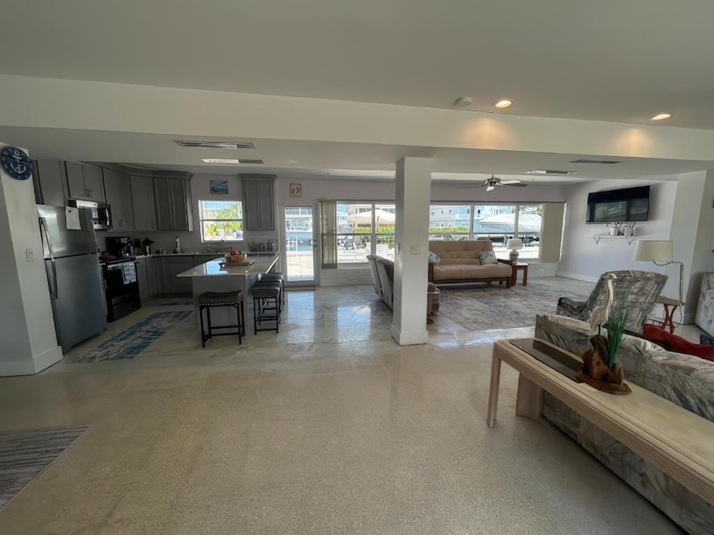 Una sala de estar y una cocina con un sofá y una mesa. en Comfortable, Spacious 3-BR, 2-BA-1 level home- DEEP dock on canal, Islamorada, en Islamorada