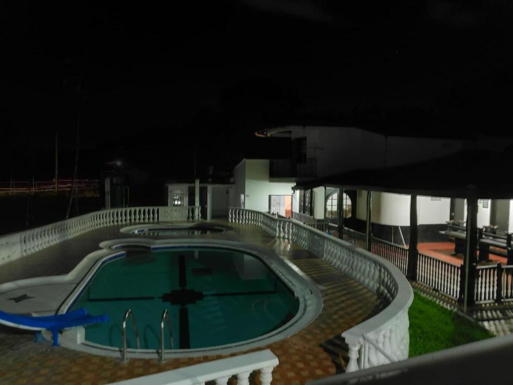 a swimming pool at night next to a building at Finca Campestre Foundation Ecopiensa Evolution in Andalucía