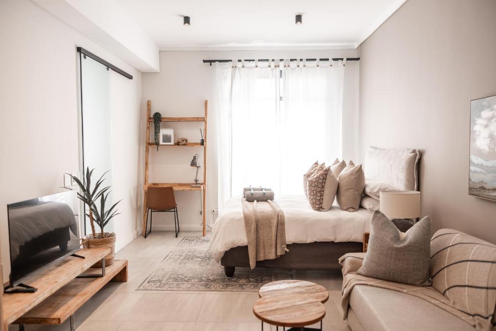 a living room with a bed and a couch at 222 at Maine in Pretoria