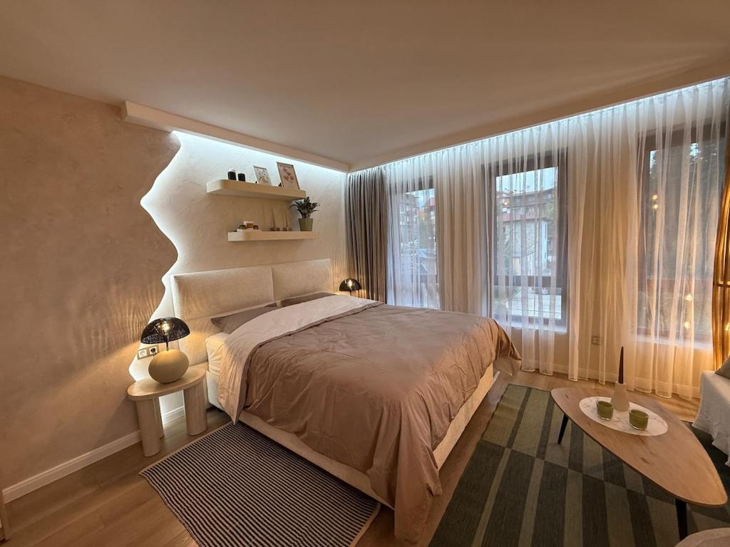 a bedroom with a bed and a large window at Appartement moderne et chic Ski & Spa Bansko in Bansko